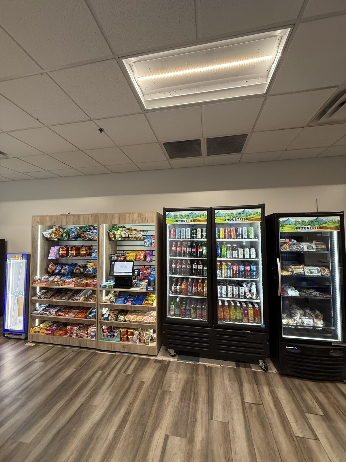 Stocked snack displays and illuminated beverage refrigerators form a completed commercial micro-market installation.