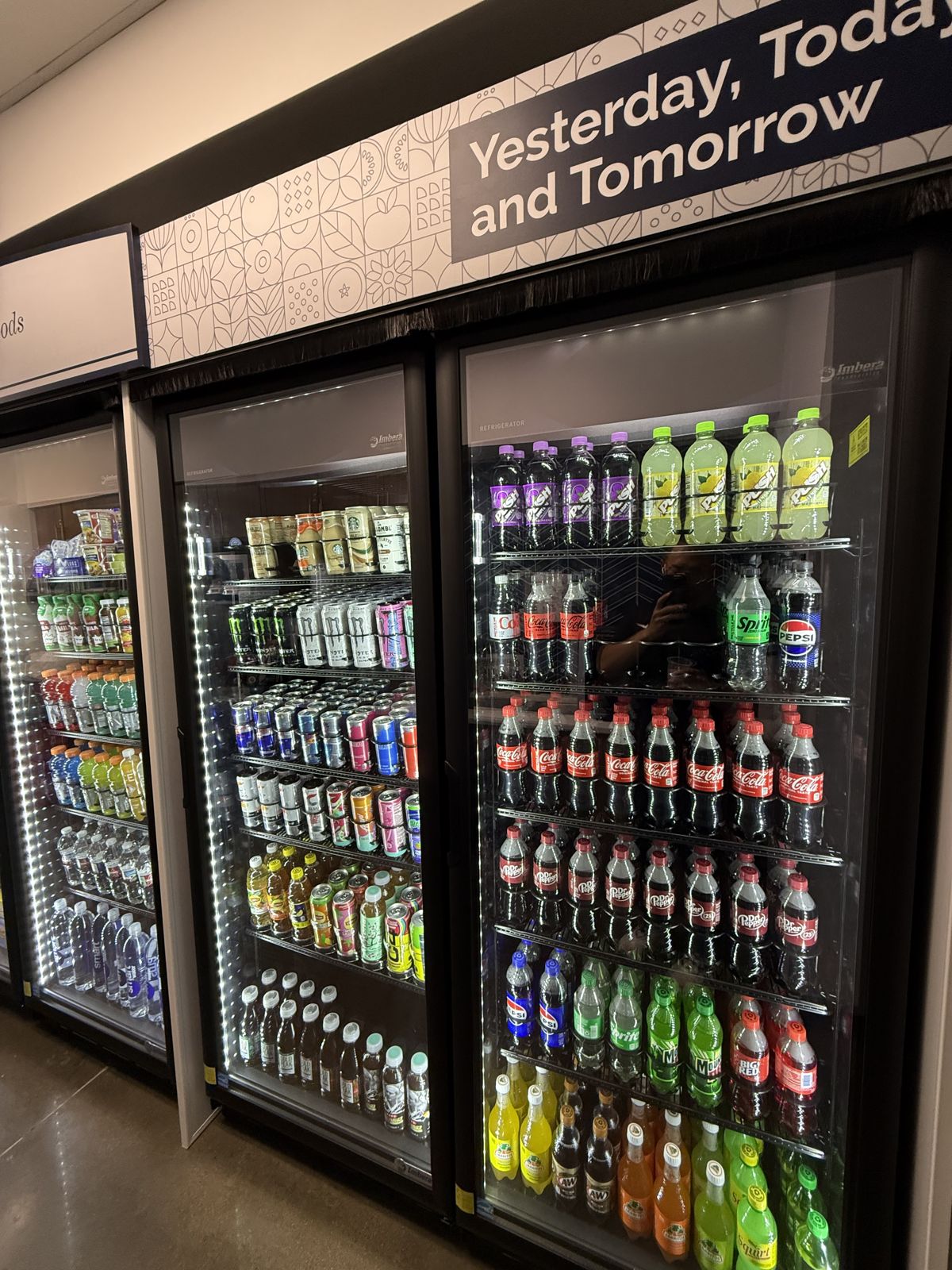 A row of illuminated glass-front coolers displays neatly stocked beverages after installation.
