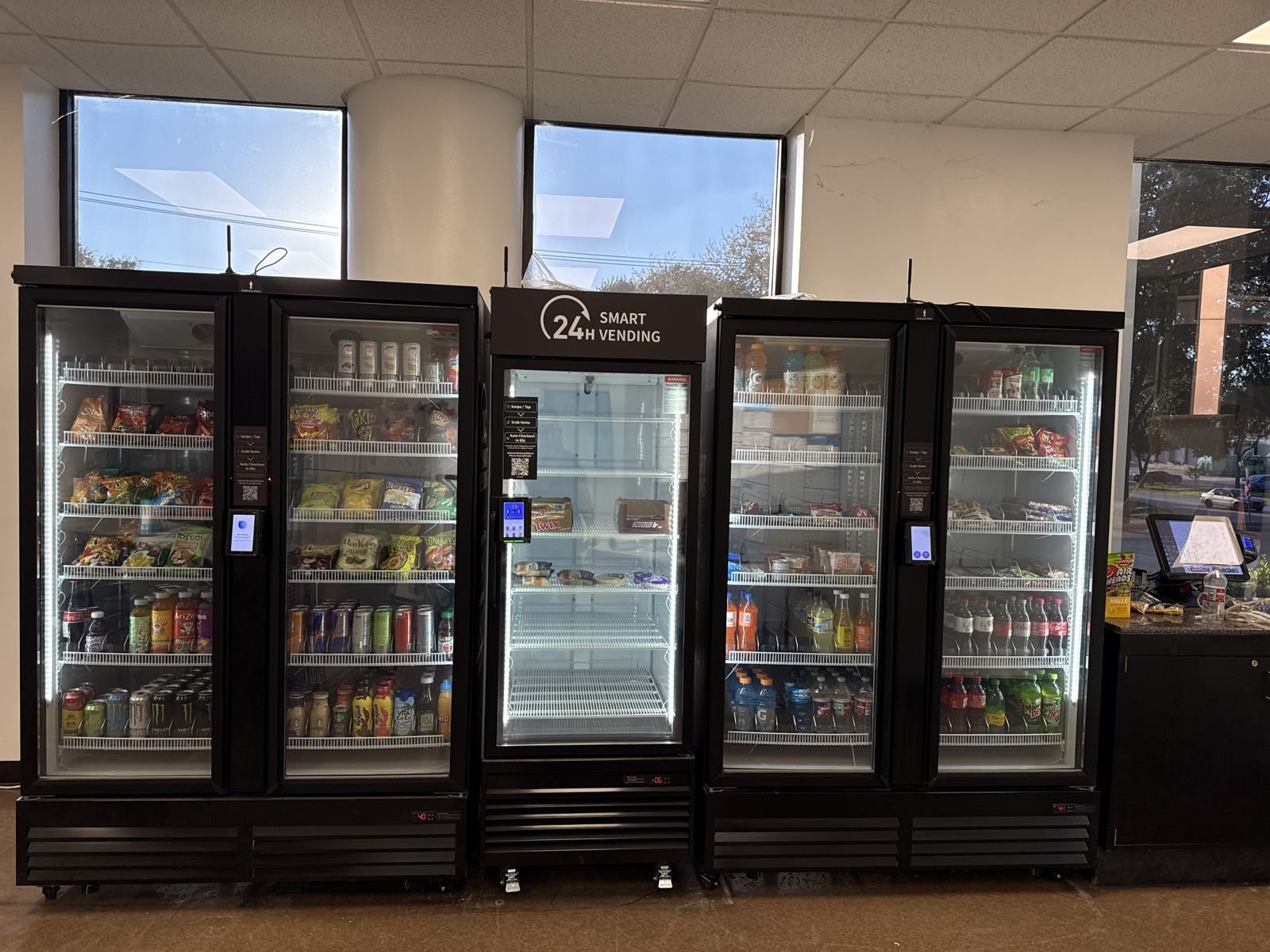 Five stocked glass-front vending coolers stand in a completed commercial installation.
