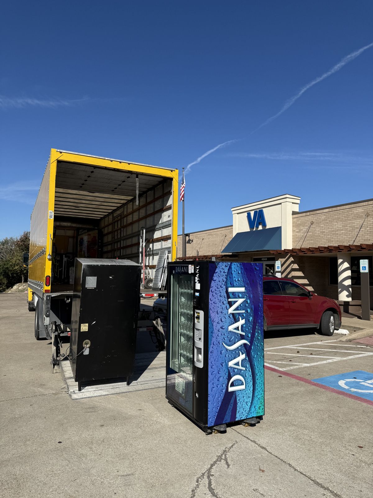 TL Moving crew delivering vending machines beside the moving truck at a commercial facility