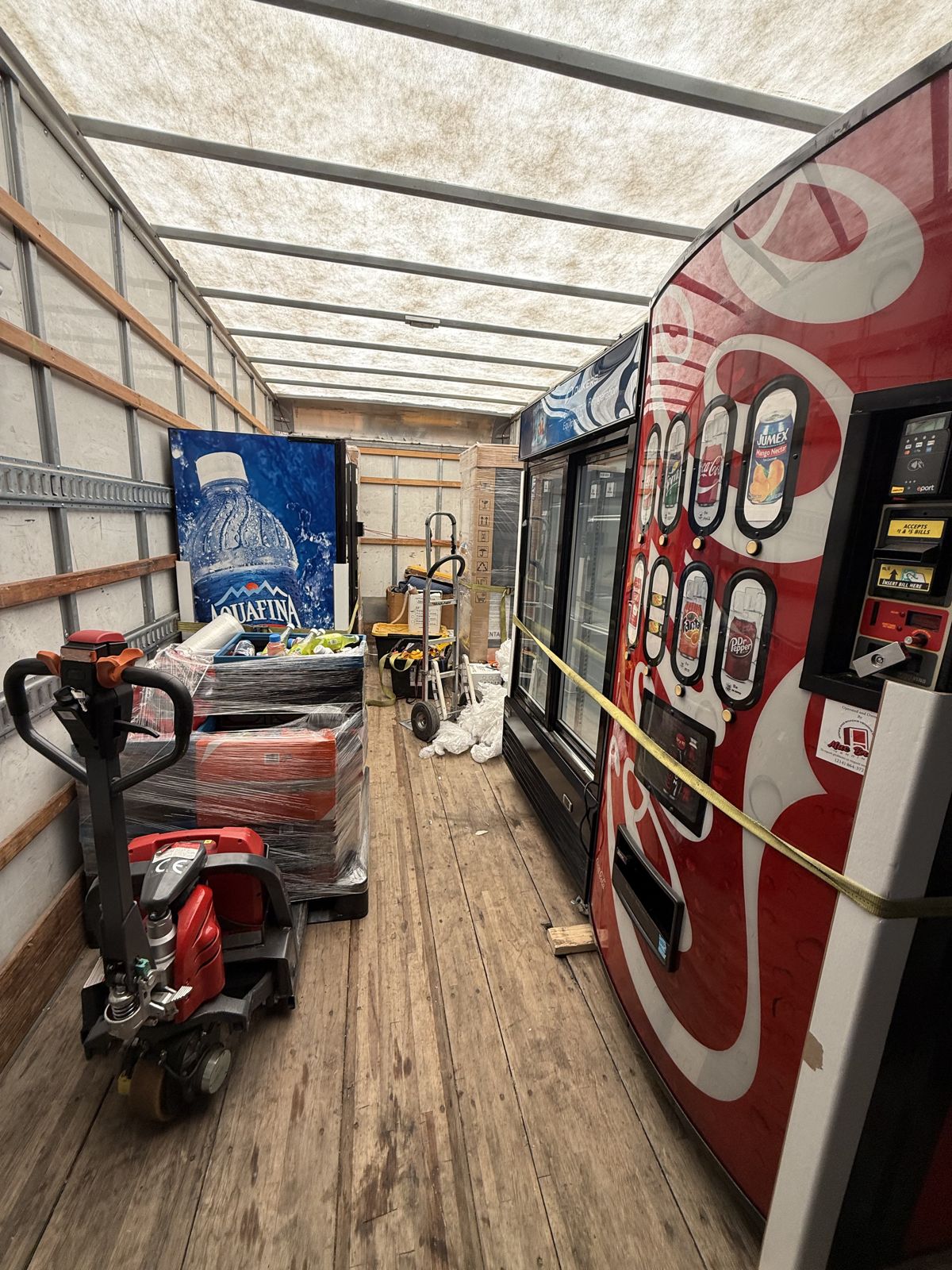 TL Moving equipment secures multiple vending machines and pallet jacks inside a box truck.