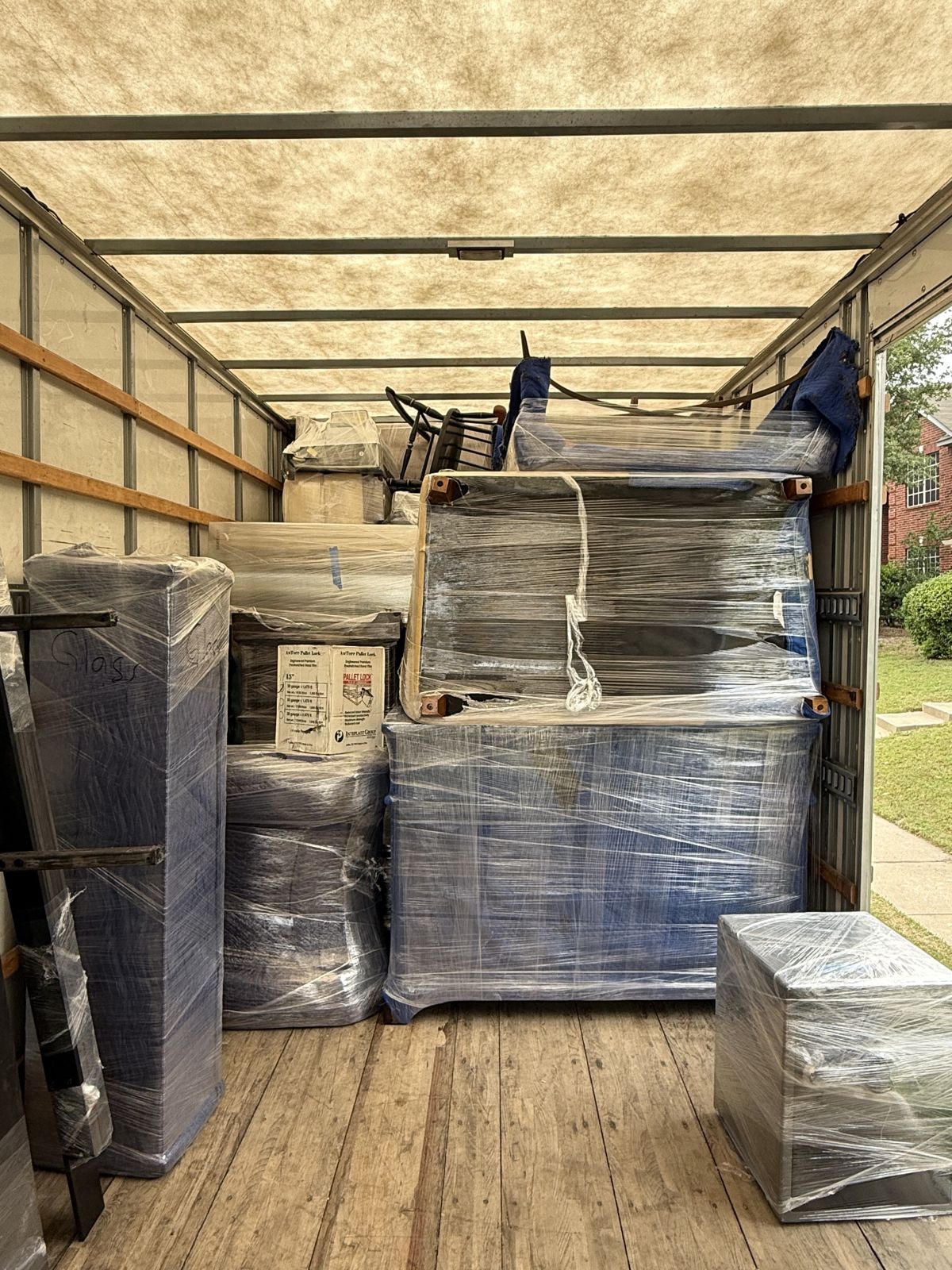 Carefully wrapped furniture and household items are arranged inside a moving truck.